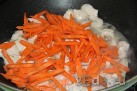 Морковь очистить, нарезать на брусочки (или натереть на тёрке), добавить в сковороду и обжарить в течение 3 минут вместе с курицей, иногда помешивая.