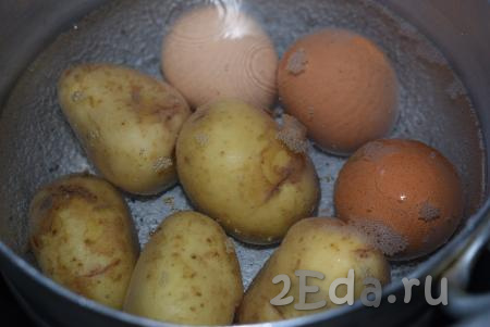 Картофель в мундире и яйца нужно отварить до готовности, для этого вымытые яйца и картошку отправляем в кастрюлю с холодной водой, ставим на огонь, с момента закипания варим на небольшом огне яйца 10 минут, а картофель - до готовности (примерно, 20 минут). Готовность картофеля проверяем, прокалывая клубни ножом (если нож легко прокалывает картофелину - значит готова).
