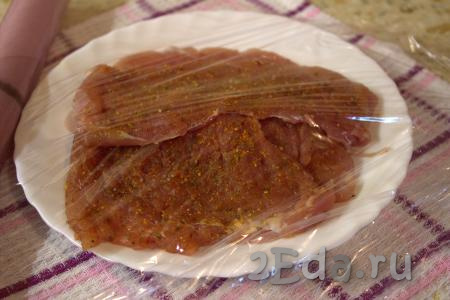 Посолить каждый отбитый кусочек мяса, приправить по вкусу. Сложить куски свинины в тарелку, накрыть пищевой плёнкой и отставить в сторону на 20-30 минут.
