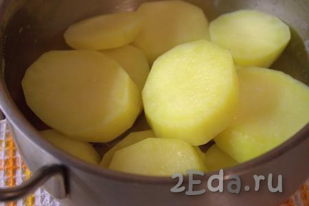 Выложить кружочки картофеля в кастрюлю, залить холодной водой и поставить на огонь. После закипания воды огонь уменьшить до минимума и отварить картошку в течение 2-3 минут. Затем слить воду, картофель посолить и приправить специями по вкусу. Дать картошке немного остыть.