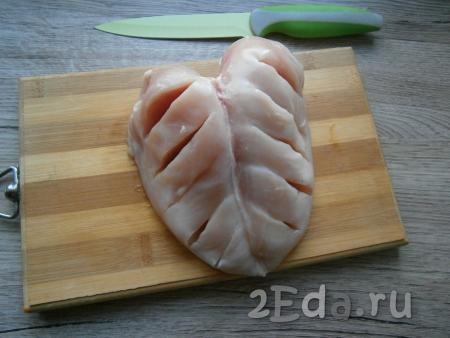 С куриной грудки срезать шкуру, оставить мясо на кости, сделать по 5 глубоких разрезов слева и справа грудки.