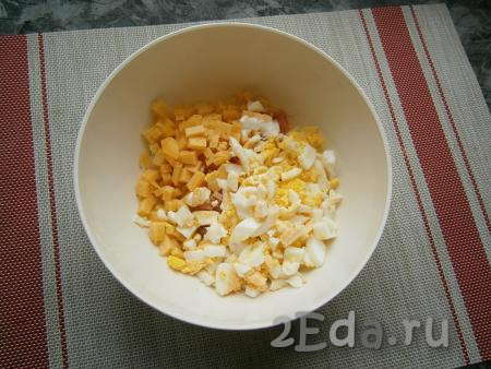 Порубить яйца ножом (не мелко). Добавить в салатник рубленные яйца и нарезанный маленькими кубиками сыр.