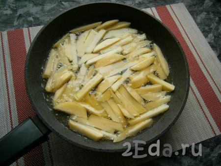В сковороде (у меня диаметр сковороды 24 см) разогреть 1 стакан подсолнечного масла и выложить картошку так, чтобы она была расположена в один слой.