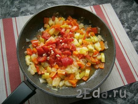 Через 15 минут добавить к овощам помидоры и мелко нарезанный чеснок, перемешать и протушить рагу на небольшом огне ещё 3-4 минуты.