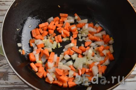 На сковороду влейте и раскалите 1 столовую ложку растительного масла, выложите нарезанные лук с морковкой и обжаривайте на слабом огне в течение 5-6 минут, помешивая, затем переложите в кастрюлю. Получается, что между этапом загрузки картофеля и загрузкой в кастрюлю обжаренных овощей проходит 7-8 минут.