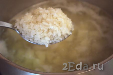 Снова дать бульону закипеть, затем выложить в него нарезанную картошку. Как только бульон с картофелем закипит, добавить рис, предварительно промытый в нескольких водах. Варить бульон с рисом и картошкой на среднем огне, примерно, 20 минут (до готовности картофеля с рисом).