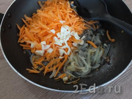К обжаренному луку добавьте крупно порубленный очищенный чеснок, а также натёртую на крупной тёрке очищенную морковь.