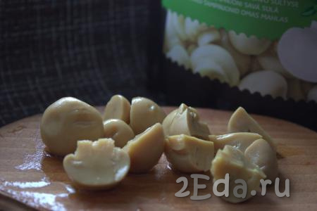 Крупные маринованные грибы разрезать на несколько частей (слишком мелко резать не нужно). Например, крупные маринованные грибы можно разрезать на 4-6 частей.