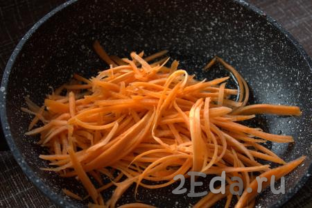 В сковороде разогреть растительное масло, выложить в сковороду натёртую (или нарезанную) морковь и обжарить, помешивая, на среднем огне до готовности (5-7 минут). Готовую морковь снять с огня и дать слегка остыть.