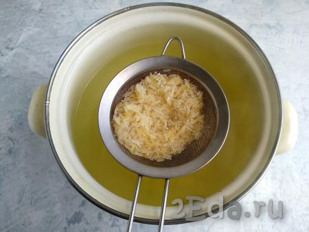Рис промыть в холодной воде, выложить в кастрюлю, продолжать готовить суп минут 10.