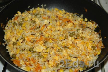 Перемешать рис с овощами и яйцами, влить соевый соус и посолить по вкусу.