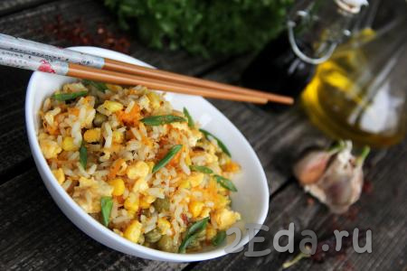 Подать аппетитный рис, приготовленный с овощами и яйцами по-китайски, к столу в горячем виде, посыпав мелко нарезанной зеленью. Очень вкусно и сытно, попробуйте!