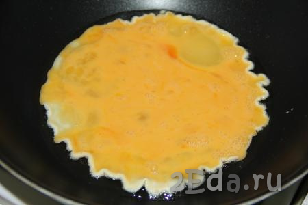 В сковороду влить немного масла и влить яйца, равномерно распределив их по дну сковороды.