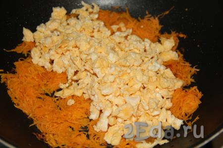 Затем к моркови добавить жареные яйца, перемешать. Сюда же выложить и мелко нарезанный чеснок.