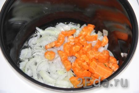 Почистить морковку и лук. В чашу мультиварки влить масло, выложить мелко нарезанный лук и морковку, нарезанную на кубики, обжарить их в течение 10 минут на режиме "Жарка", постоянно помешивая.