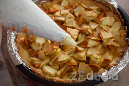 Вынимаем из духовки пирог с яблоками и хурмой. На его поверхность начинаем наносить белковый крем, отсаживая звёздочки (крем можно аккуратно разложить по верху пирога и с помощью ложки, обойдясь без кулинарного мешка и насадок).