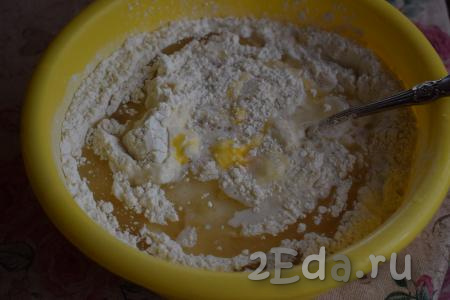 Сюда же добавляем яйцо и растительное масло, начинаем замешивать тесто. Сначала при помощи ложки, как только тесто свернётся в ком, продолжаем замес руками.