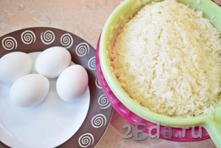 Для приготовления салата, первым делом, отварите яйца и рис. Яйца варите в кипящей воде минут 8, затем горячую воду слейте и охладите их в холодной воде.

60-70 грамм сухого риса хорошо промойте, после этого выложите в кастрюлю с кипящей подсоленной водой, доведите до кипения, а затем варите рис на небольшом огне до готовности (на это потребуется минут 15-20). Готовность риса проверяйте на вкус. Рисинки должны стать мягкими, но не разваренными. Готовый рис откиньте на дуршлаг и немного промойте холодной водой. Дождитесь, чтобы с риса стекла лишняя жидкость и он остыл. Для приготовления салата потребуется 150 грамм отваренного риса.