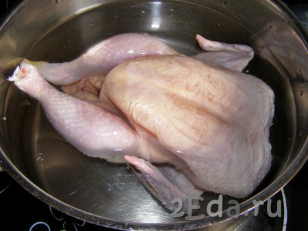 Сначала сварим бульон. Я для лукового супа предпочитаю готовить насыщенный куриный бульон, поэтому варю всю курицу целиком (вес курочки, примерно, 1,2 килограмма), вы же можете использовать 1/4 часть от курицы (к примеру, окорочок весом 300-400 грамм). Курицу моем холодной водой, затем перекладываем в кастрюлю и заливаем чистой холодной водой так, чтобы она полностью покрывала курицу. Добавляем соль и ставим на сильный огонь.