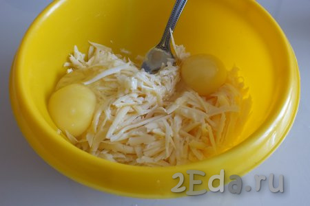 В миску натрите сыр, добавьте два сырых яйца, подсолите, перемешайте вилкой.