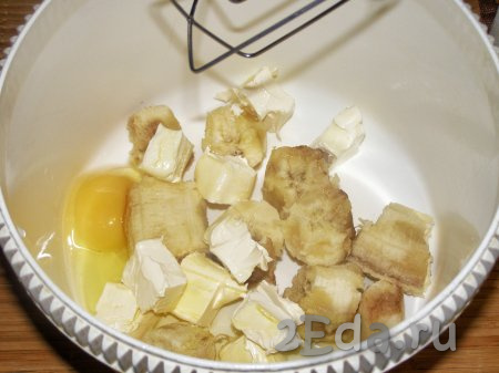 Для приготовления этого печенья лучше брать зрелые, мягкие бананы. Масло нужно заранее достать из холодильника и дать ему полежать при комнатной температуре около часа, чтобы оно стало мягким. Банан очищаем, разламываем на кусочки и выкладываем в чашу миксера, добавляем кусочки мягкого сливочного масла и яйцо, перемешиваем на низкой скорости миксера до однородного состояния.