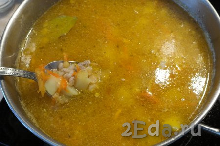 Затем выложите в суп варёные горох и перловку, доведите до кипения, а после этого варите на минимальном огне минут 15-20. За 5 минут до готовности добавьте лавровый лист.