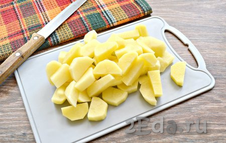 Очистить картофель. Ополоснуть клубни под холодной водой и нарезать средними брусками. Когда капуста проварится минут 10, выложить в кастрюлю картошку и варить ещё 7-10 минут.