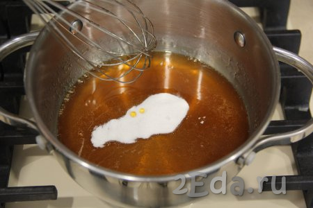 Мёд выложить в сотейник, поставить на небольшой огонь и прогреть, помешивая, до растапливания мёда (мёд должен стать достаточно жидким), затем всыпать соду.