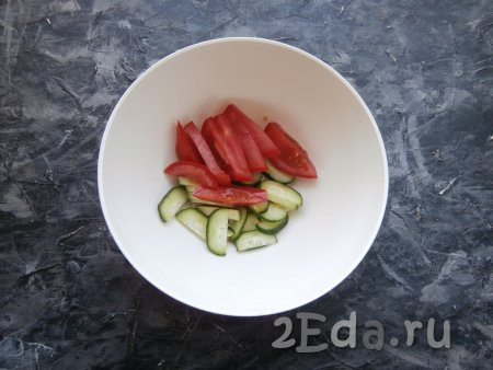 В глубокую миску (или тарелку) огурец нарезать тонкими полукружочками, помидор - дольками.