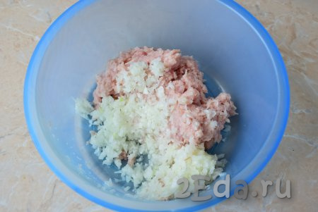 Переложите куриный фарш в достаточно объёмную миску, добавьте очищенную луковицу, пропущенную через мясорубку (или прокрученную в измельчителе).