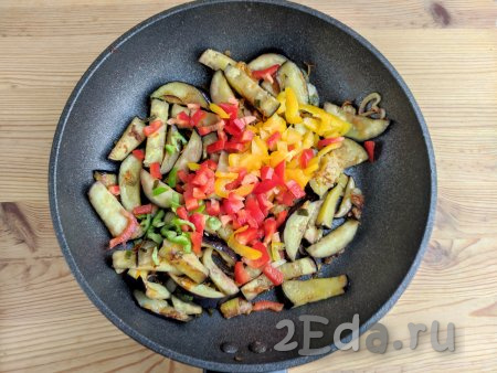 Выложить перцы в сковороду, обжаривать овощи, помешивая, 2-3 минуты.
