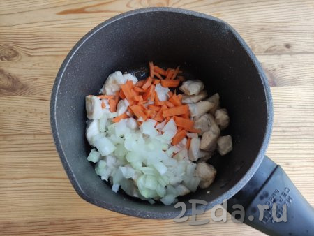 Когда мясо покроется золотистой корочкой, выложить к нему лук и морковь, обжаривать, не забывая перемешивать, минут 7-8 (до прозрачности овощей).