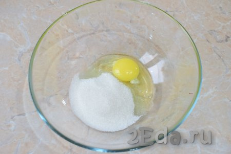 Вначале замесим тесто для оладий, для этого в достаточно глубокой миске слегка перемешайте венчиком яйцо с сахаром.
