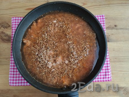 Влить в сковороду горячую воду из чайника. Сковороду накрыть крышкой и готовить гречку с фаршем и томатной пастой около 15 минут на медленном огне.
