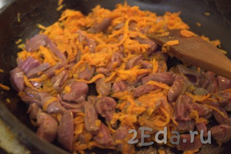 Затем к моркови в сковороду добавить куриные сердечки, хорошо перемешать и обжаривать, не забывая помешивать, на среднем огне минут 10.