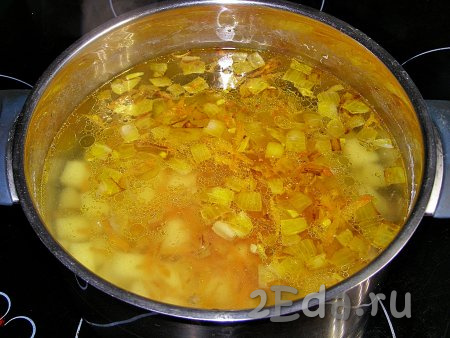 Когда картошка станет мягкой, достаём из кастрюли лавровый лист. Выкладываем в кастрюлю с картошкой обжаренные лук с морковью и чесноком. Приправы, которые обычно добавляются в пакетики с лапшой, также можно положить в суп. Солим суп (учитывайте, что в состав приправ, которые прилагаются к "Роллтону", есть соль). На сильном огне доводим суп до кипения.