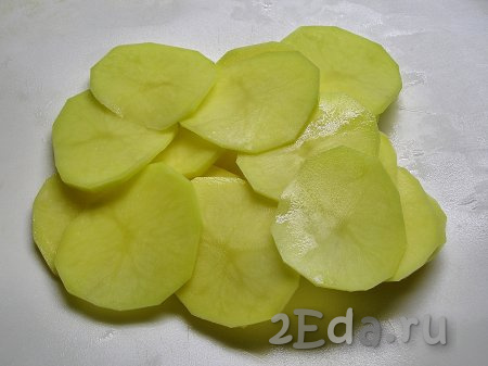 Картошку моем, чистим и нарезаем на тонкие ломтики толщиной, примерно, 1 мм или тоньше. Для нарезки можно воспользоваться овощечисткой.