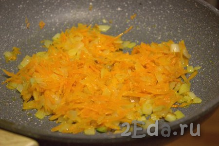 В сковороду влить растительное масло, выложить лук и обжарить его на среднем огне, помешивая, до прозрачности (примерно, 3-5 минут). Затем добавить в сковороду морковь и обжарить овощи в течение 5 минут, помешивая.