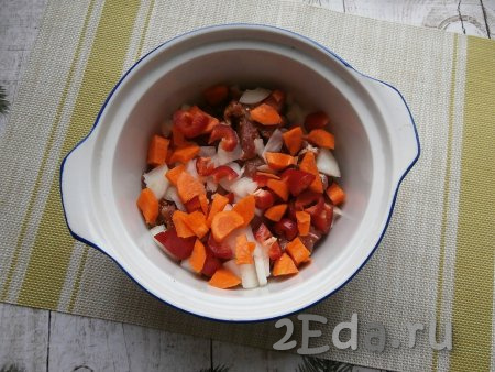 Очистить морковку с луком, из перца удалить семечки, а затем нарезать эти овощи на средние кусочки и выложить в форму (или кастрюлю) поверх свинины.