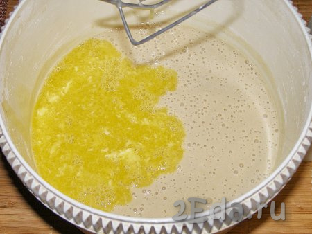 Добавляем растопленное на плите (или в микроволновке) негорячее сливочное масло в получившееся тесто, снова перемешиваем.