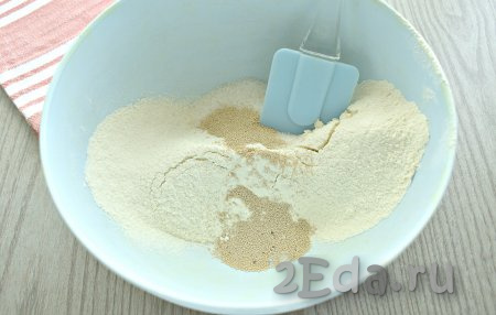 В миску просеиваем 100-115 грамм муки, затем всыпаем сахар, сухие дрожжи и соль, перемешиваем.