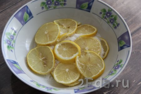 Лимоны нарезать на тонкие кружочки и выложить в глубокую миску, немного пересыпая слои сахаром. Можно несколько лимонных долек отложить для подачи лимонада.