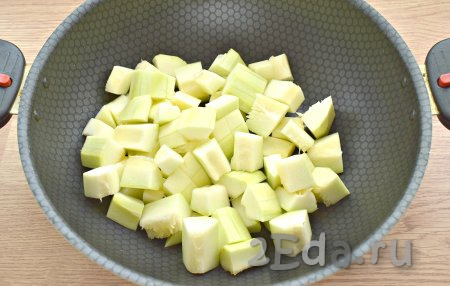 Кабачки, очищенные от кожуры и семян, нарезаем на небольшие кубики и перекладываем в глубокую сковороду (или в казан, или в сотейник).