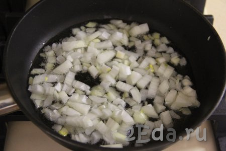 В сковороде прогреть растительное масло, затем выложить мелко нарезанный лук, обжарить его до мягкости (в течение 3-4 минут), помешивая, на среднем огне.