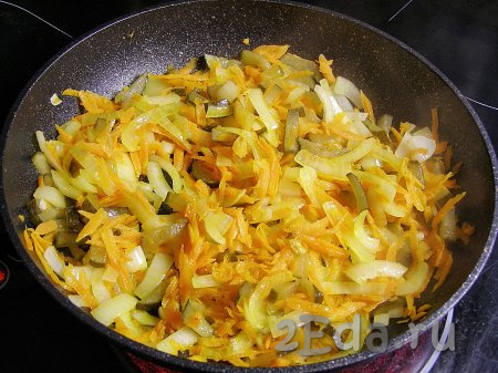 В сковородку наливаем растительное масло, немного разогреваем на сильном огне, уменьшаем огонь до среднего и выкладываем лук, огурцы и морковь. Обжариваем, иногда перемешивая, примерно 10 минут (овощи должны стать достаточно мягкими).