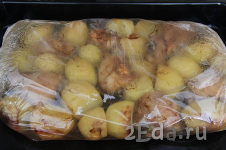 Запекать картошку с куриными бёдрами в разогретой духовке в рукаве при температуре 200 градусов 1 час.