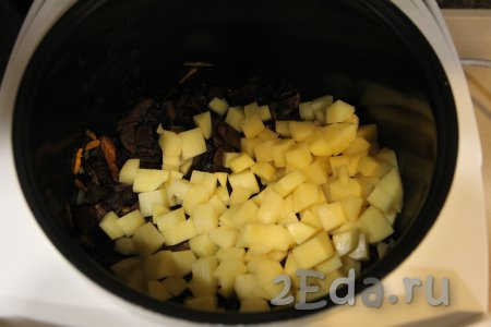 Когда морковка станет достаточно мягкой, выложить в чашу подготовленные грибы, перемешать и обжарить с овощами в течение 5 минут, периодически их перемешивая. Крышку мультиварки закрывать не нужно. Затем добавить картошку, нарезанную на средние кубики.