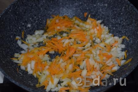 Помидоры натираем на крупной терке. В глубокой сковороде разогреваем растительное масло и выкладываем лук с морковью, обжариваем их на среднем огне до прозрачности лука, накрыв сковороду крышкой, периодически помешивая.