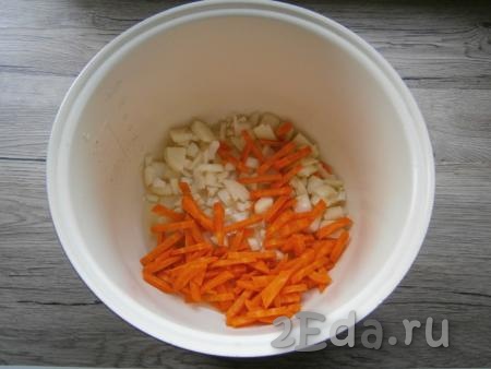 Очистить морковь и лук. В чашу мультиварки влить растительное масло, добавить нарезанный средними кусочками репчатый лук и морковь, нарезанную брусочками. Выставить программу "Выпечка" или "Жарка" на 20 минут. Помешивая овощи, жарить их 10 минут.