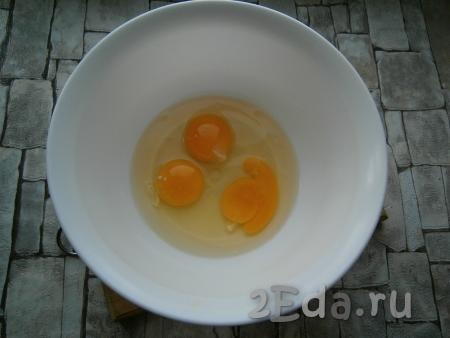 Разбить три охлажденных яйца в миску, добавить щепотку соли.